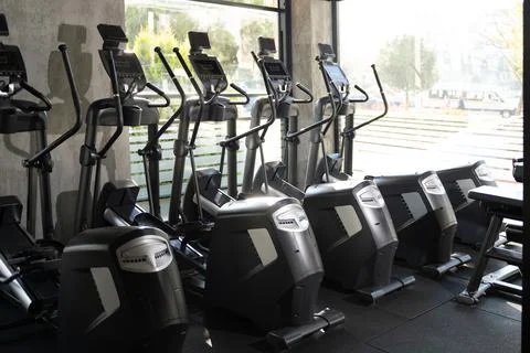 Five Elliptical Machines Side by Side in Gym Stock Photos