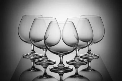 Five empty glasses for brandy with reflections Стоковые фото