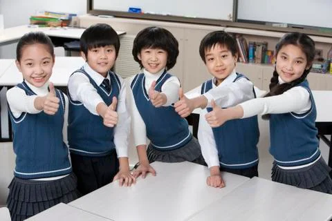 Five excited students in the classroom Stock Photos