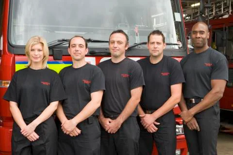 Five firefighters standing in front of fire engine Stock Photos