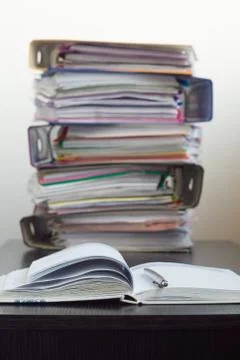 Five folders with documents stacked in a pile on the table Stock Photos