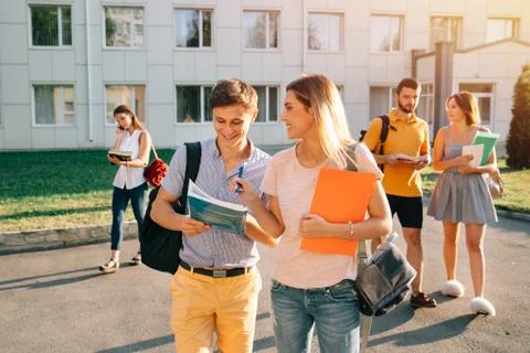 Five friendly students are walking after they passed test outside the college Stock Photos