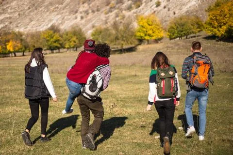 Five friends capturing from the back how going to their exhibition in the Stock Photos