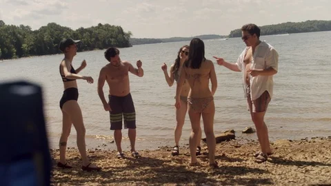 Five friends having a good time and dancing on a rocky beach at the lake Stock Footage 116785531