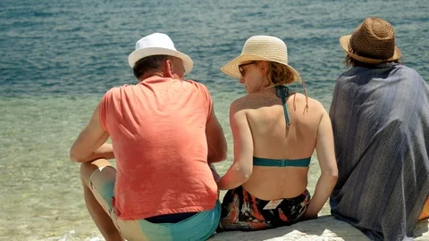 Five friends sitting on a sandy beach near the Mediterranean sea. Greece. 4K 库存影片 117916576