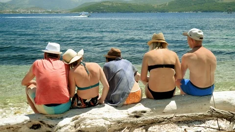Five friends sitting on a sandy beach near the Mediterranean sea. Greece. 4K Stock-Footage 118286200