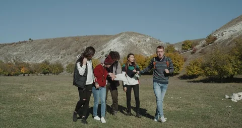 Five friends trying to find the right way looking through the map , in the Stock Footage 97624848