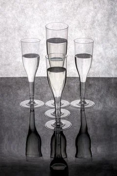Five glasses of liquid on a gray background with reflection. Foto stock