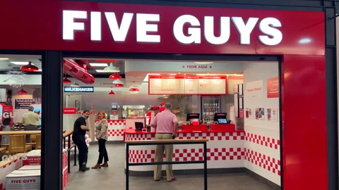 Five Guys fast food burger chain restaurant in Spain, people waiting for their Stock Footage 296580187