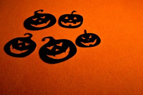 Five hand-painted black pumpkins on an orange background Stock Photos