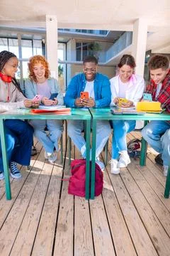 Five happy multiracial students studying with smartphones outdoors.Vertical Stock Photos