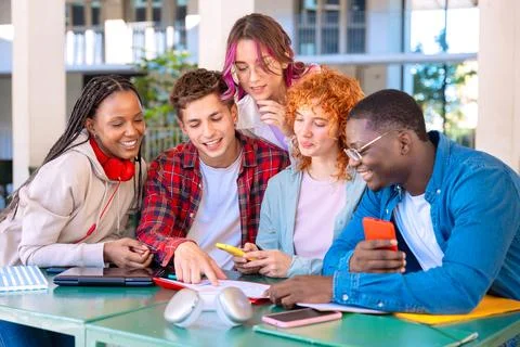Five happy multiracial students studying with smartphones outdoors. Foto stock
