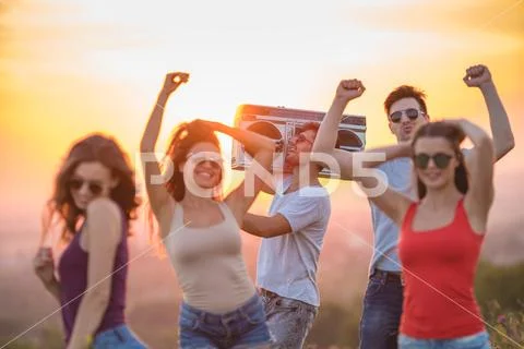 The five happy people dancing on the hill on the sunrise background Stock Photos