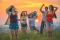The five happy people dancing on the hill on the sunrise background Photo