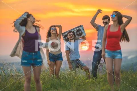 The five happy people dancing on the hill on the sunrise background Stock Photos