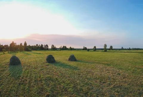 Five haystacks lined up in a row view from the height of the quadcopter at su Stock Photos