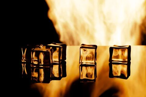 Five ice cubes on a black background, in the background flames Stock Photos