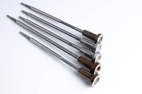 Five identical control valves aligned in a row on white background. Automot.. Stock Photos