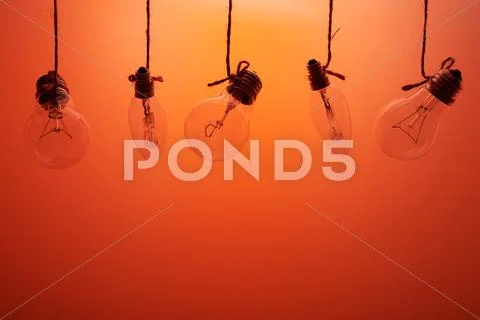 Five incandescent bulbs on a orange background Stock Photos