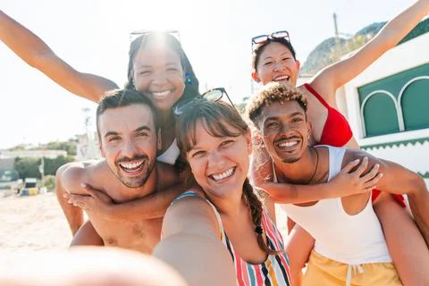 Five joyful friends capturing a memorable selfie during a sunny summer day at Stock Photos