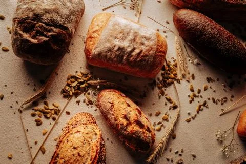 Five loafs of wheat and rye bread lying on the table in bakery Stock Photos