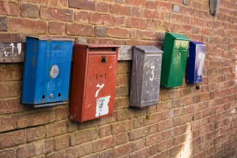 Five mailboxes hang on a brick wall Foto stock