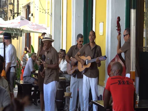 Five men musicians dressed in white trousers and brown shirt sing, play the Stock Footage 69558971