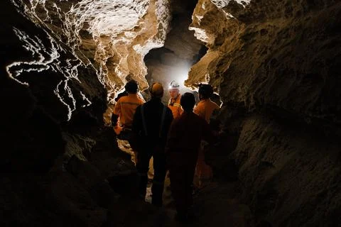 Five men, strong physique, explore the cave. Men dressed in special clothes.. Stock Photos