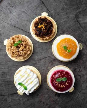 Five miniature tarts rest on rustic wood Fotos Stock
