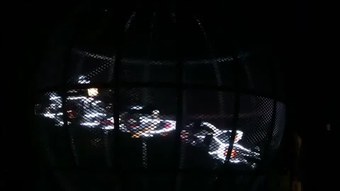 Five motorcycles performing thrilling high-speed stunts inside a cage Video stock 328382804