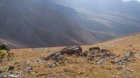 Five mountain bikers ride high mountain trail Stock Footage 83714834