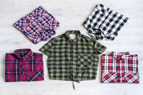 Five multi-colored checkered women's shirts lying neatly folded Stock Photos