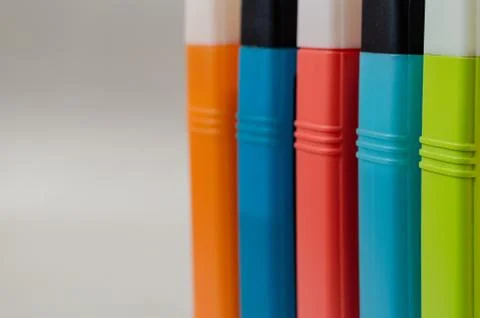 Five multi-colored plastic containers with corks. Stock Photos