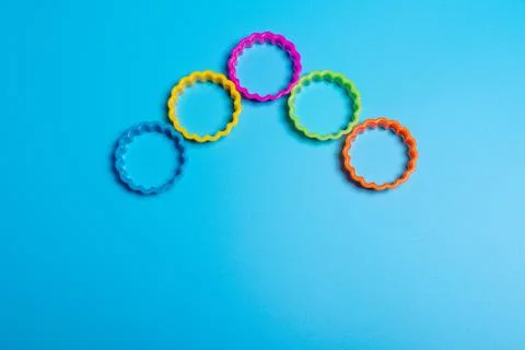 Five multi-colored plastic cookie cutter for making cookies on a blue backgro Stock Photos