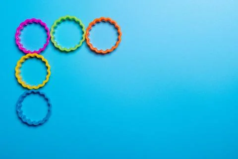 Five multi-colored plastic cookie cutter for making cookies on a blue backgro Stock Photos