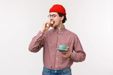 Five oclock tea. Funny and handsome young strange guy in hipster beanie, glasses Stock Photos
