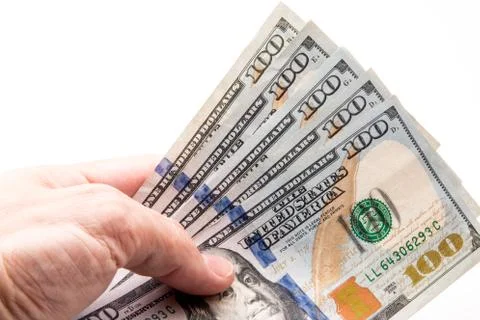 Five One hundred dollar bills being held in hand. Stock Photos