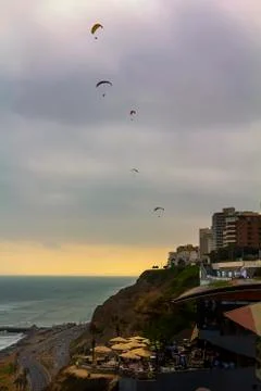 Five parasails take to flight off a cliff in Lima, Peru Stock Photos