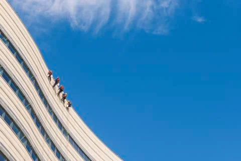 Five people abseiling down a tall building Fotos de archivo