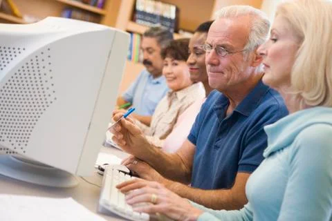 Five people at computer terminals in library (depth of field) Stock Photos