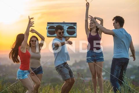 The five people dancing on the hill on the sunset background Stock Photos