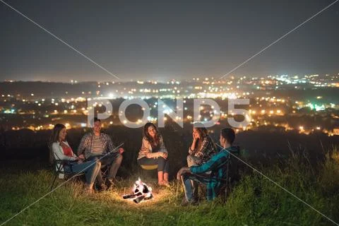 The five people relax near bonfire. night time Stock Photos