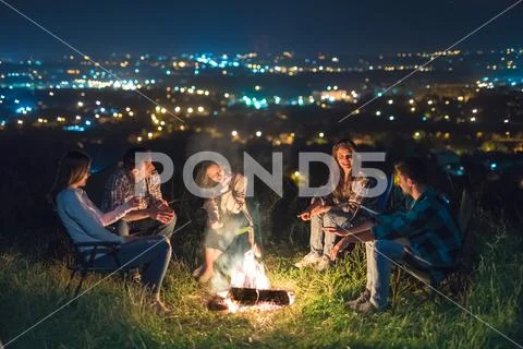 The five people rest near bonfire. night time Stock Photos