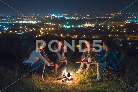 The five people rest near bonfire. night time Stock Photos