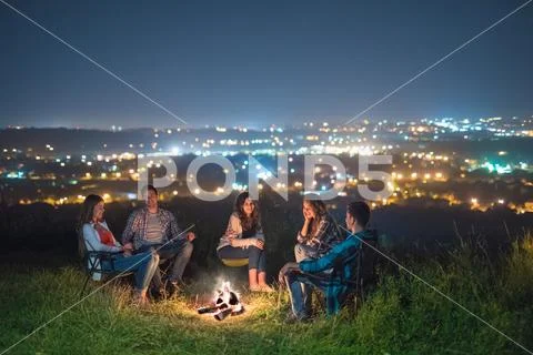 The five people rest near bonfire. night time Stock Photos