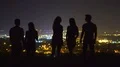 The five people stand on the background of the city lights. evening night time 4k or 4k+ Resolution