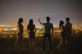 The five people stand on the background of the city and make selfie. night ti Photo