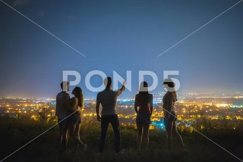 The five people stand on the background of the city lights. night time Stock Photos