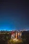 The five people stand near the bonfire on the background of the city. night t Photo