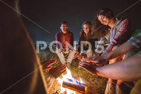 The five people warming hands near the bonfire. night time Stock Photos